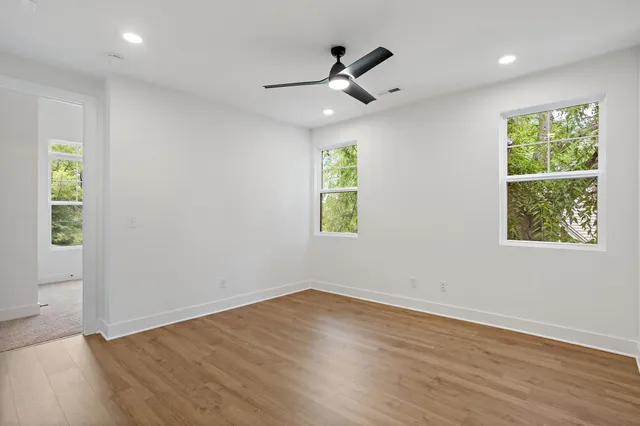 an empty room with a window and a ceiling fan