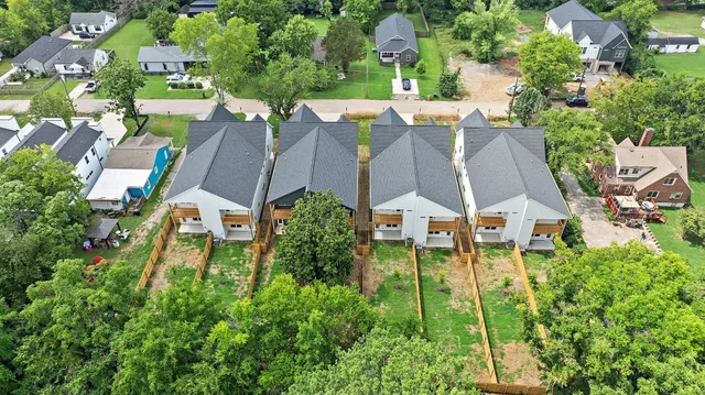 an aerial view of residential houses with outdoor space and trees