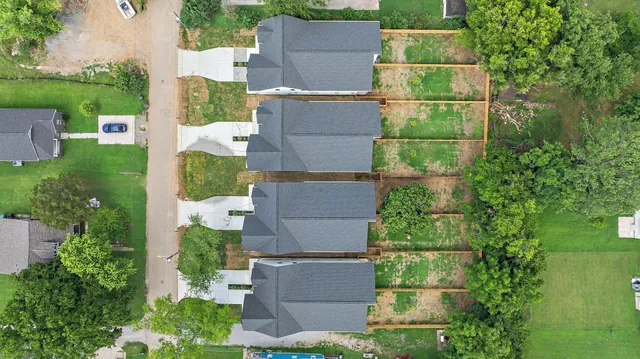 an aerial view of residential houses with outdoor space and city view