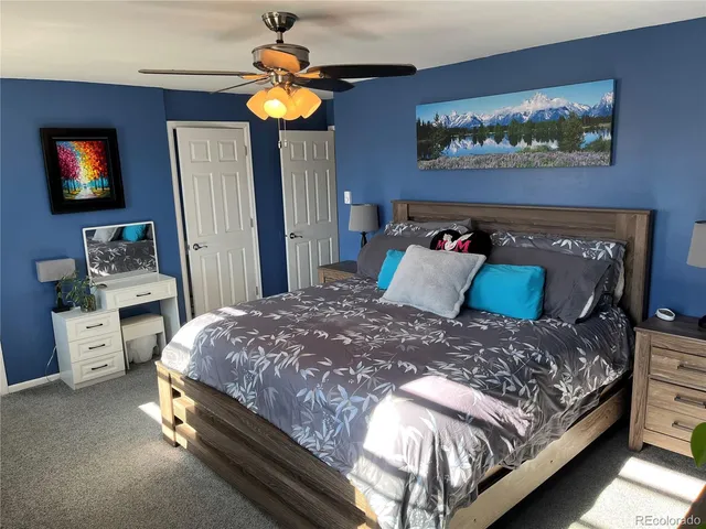 a bedroom with a bed and a painting on the wall