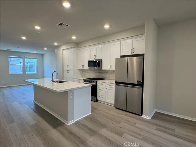 a kitchen with stainless steel appliances a refrigerator and a stove top oven