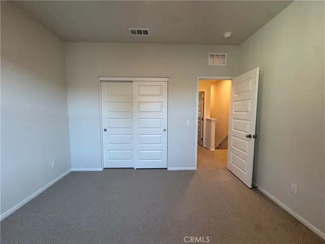 an empty room with closet and mirror