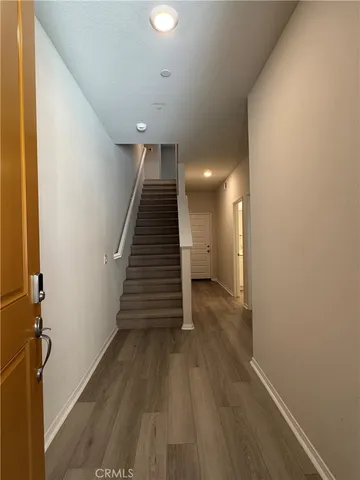 a view of a hallway with wooden floor and staircase