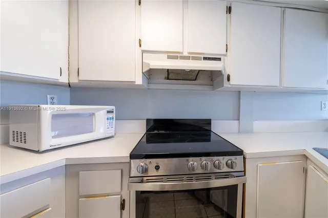a kitchen with cabinets stainless steel appliances and counter space