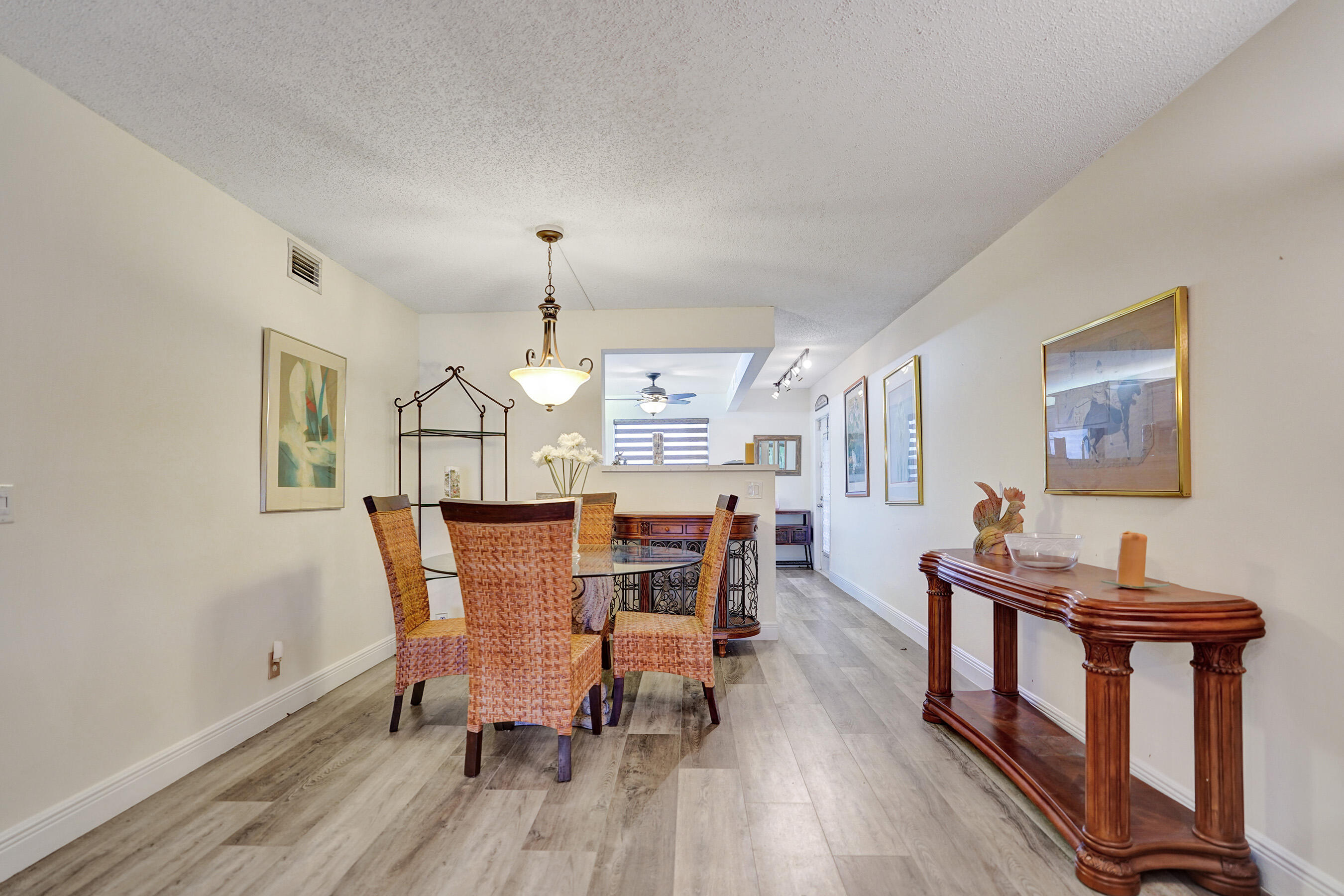1033 Ainslie C Boca Raton, FL 33434 - Photo 13 of 42 a dining room with furniture a chandelier and wooden floor