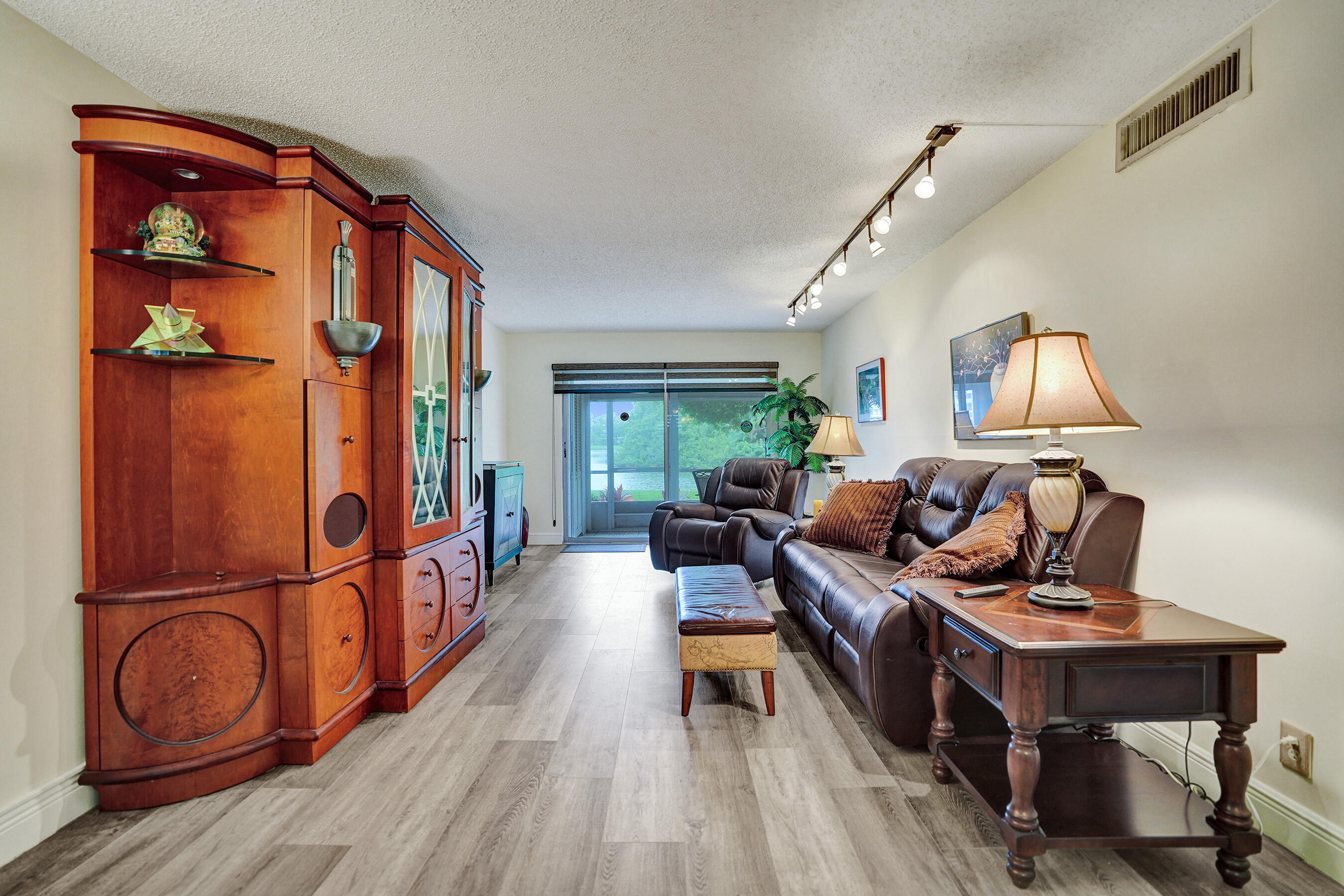 1033 Ainslie C Boca Raton, FL 33434 - Photo 15 of 42 a living room with furniture a rug and a wooden floor