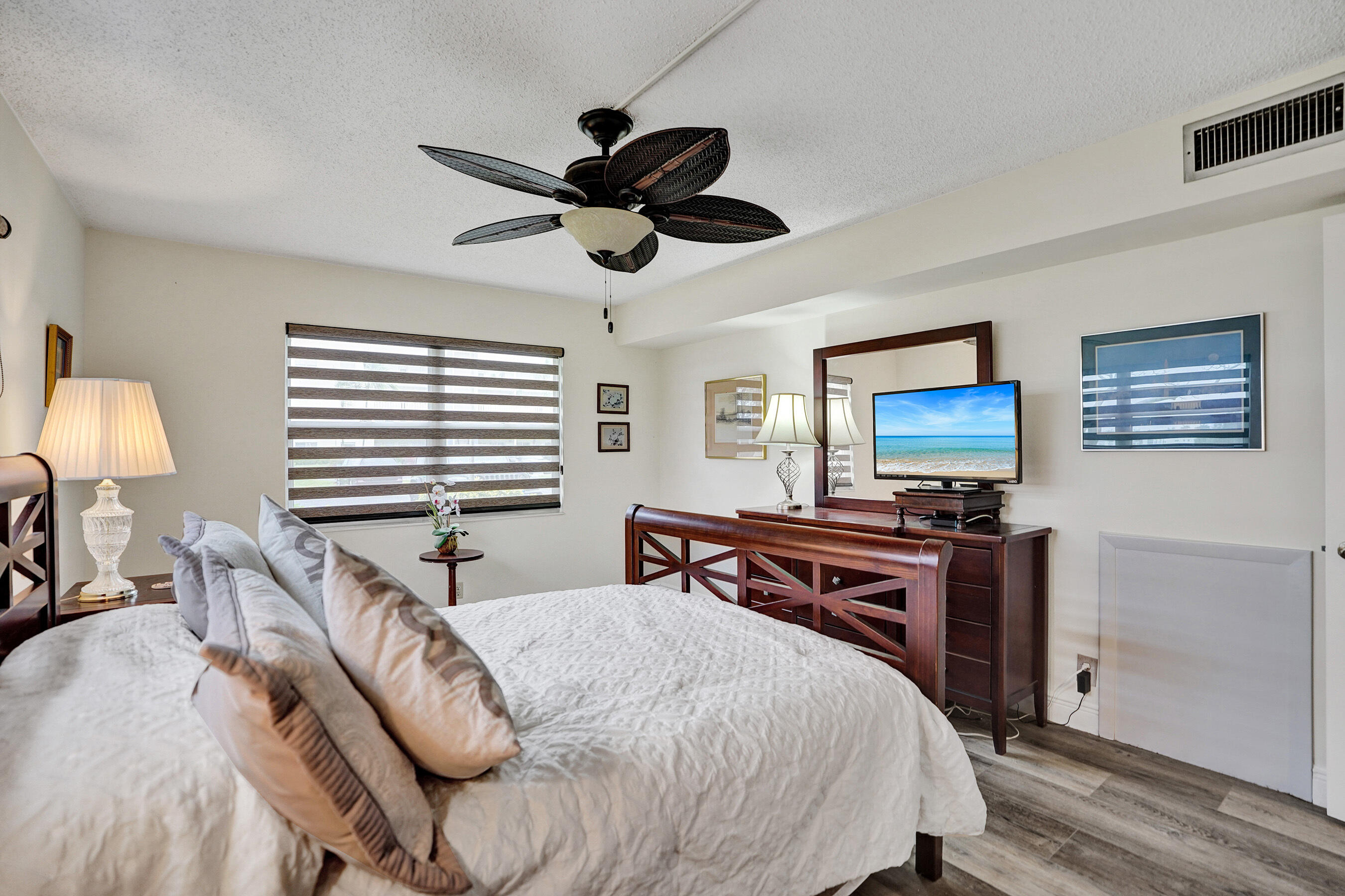 1033 Ainslie C Boca Raton, FL 33434 - Photo 26 of 42 a bedroom with a bed and a flat screen tv