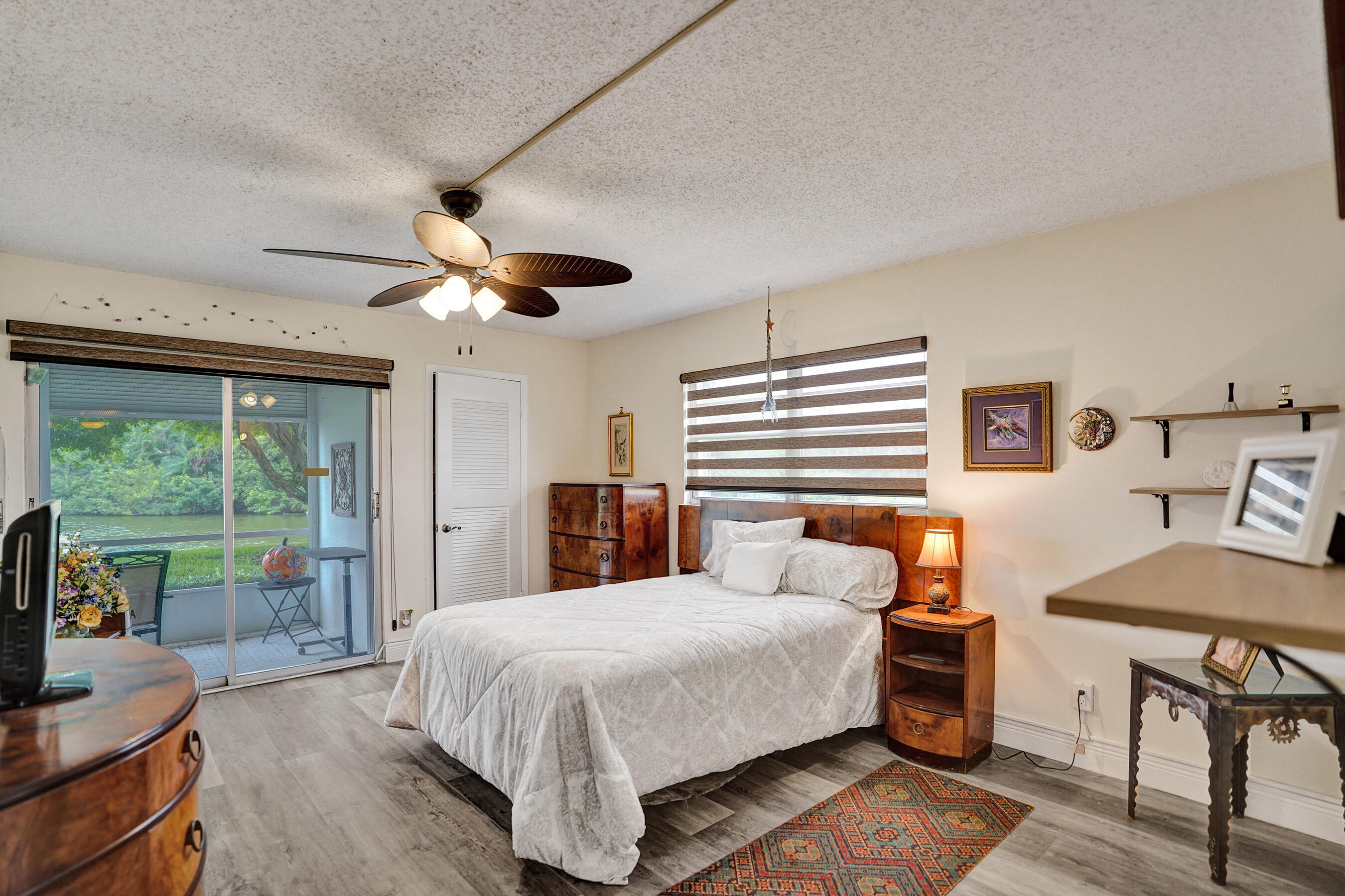 1033 Ainslie C Boca Raton, FL 33434 - Photo 27 of 42 a bedroom with a bed a chandelier and a large window