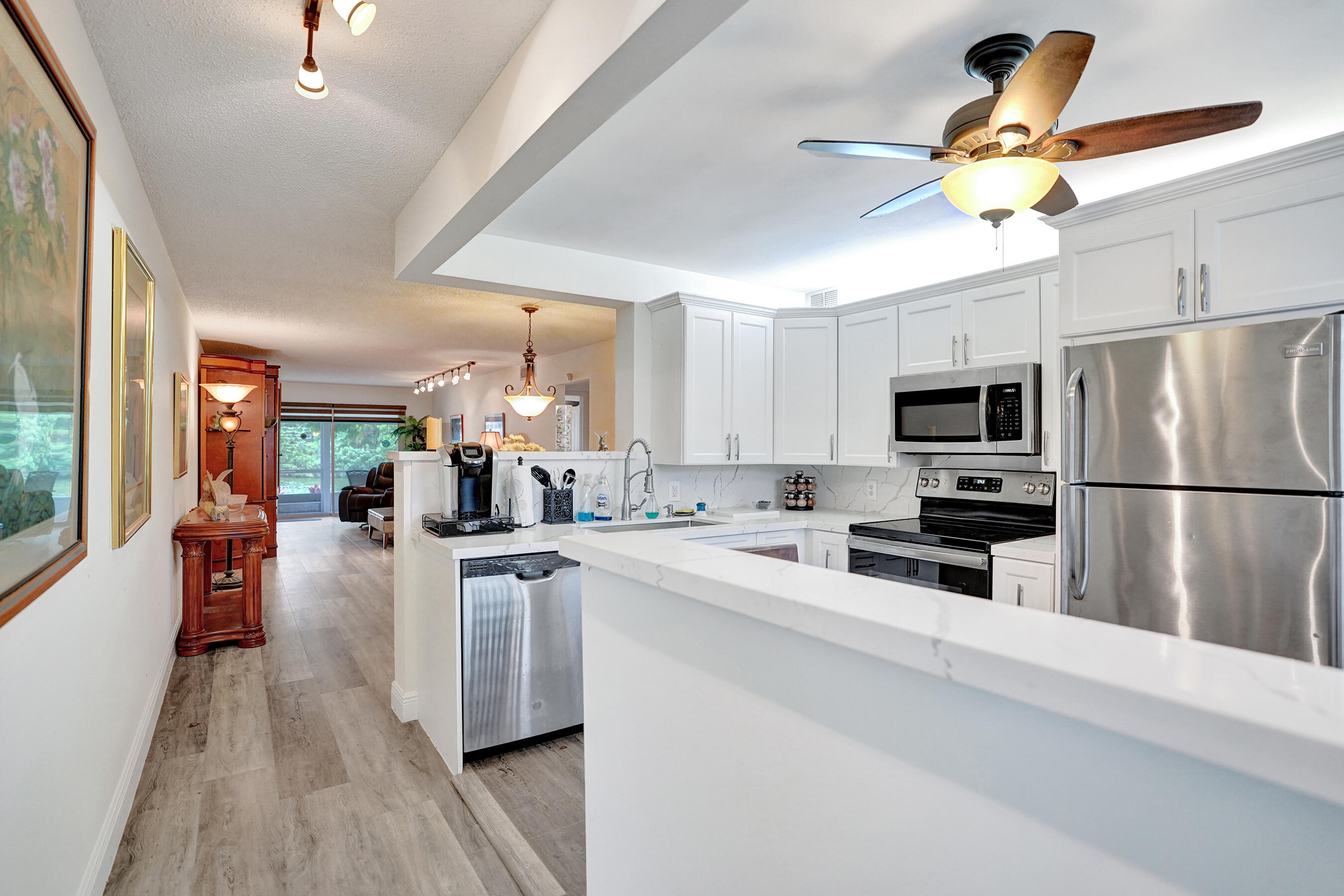 1033 Ainslie C Boca Raton, FL 33434 - Photo 3 of 42 a kitchen that has a lot of cabinets a sink and appliances