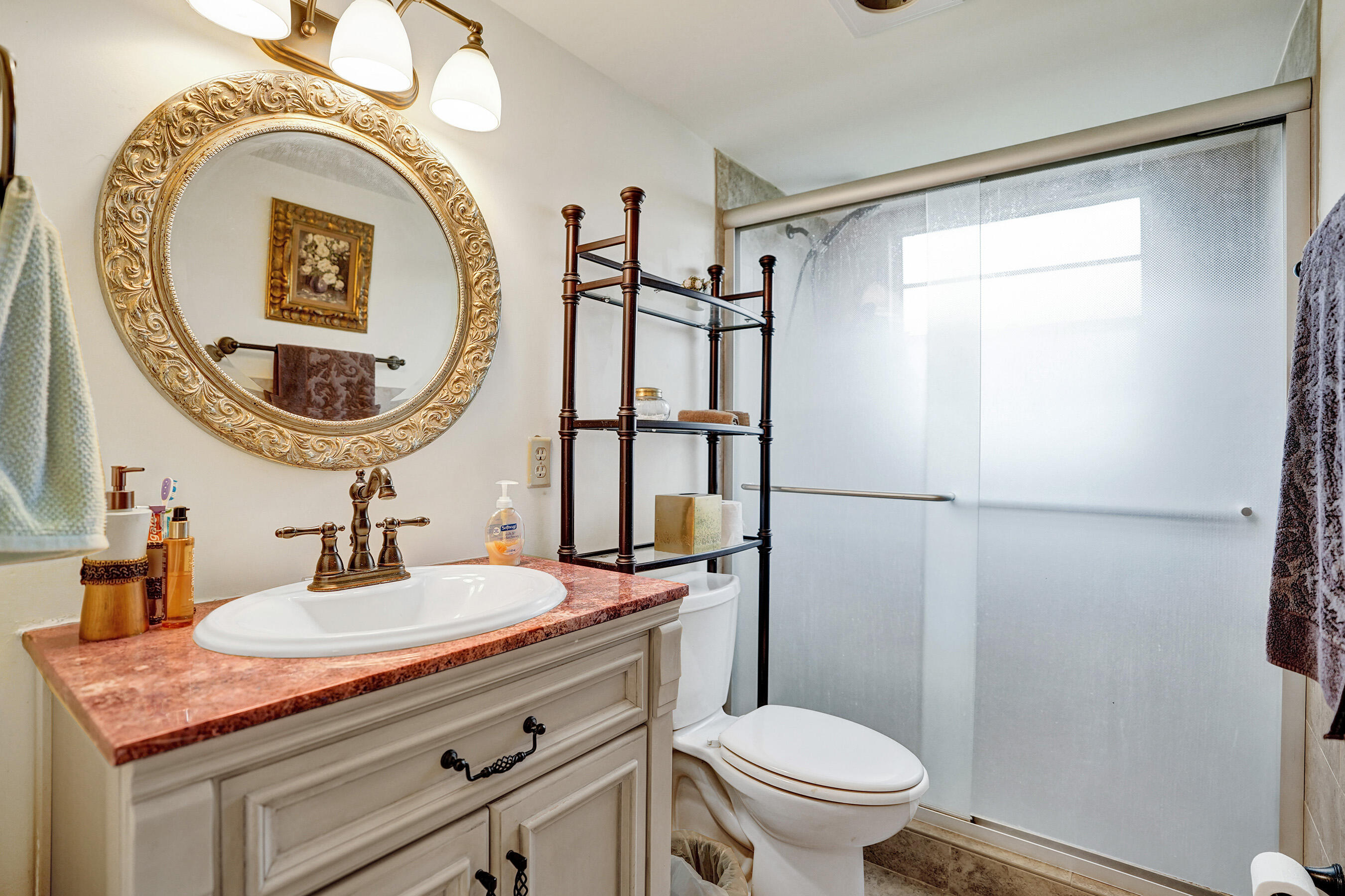 1033 Ainslie C Boca Raton, FL 33434 - Photo 32 of 42 a bathroom with a sink a toilet and a mirror