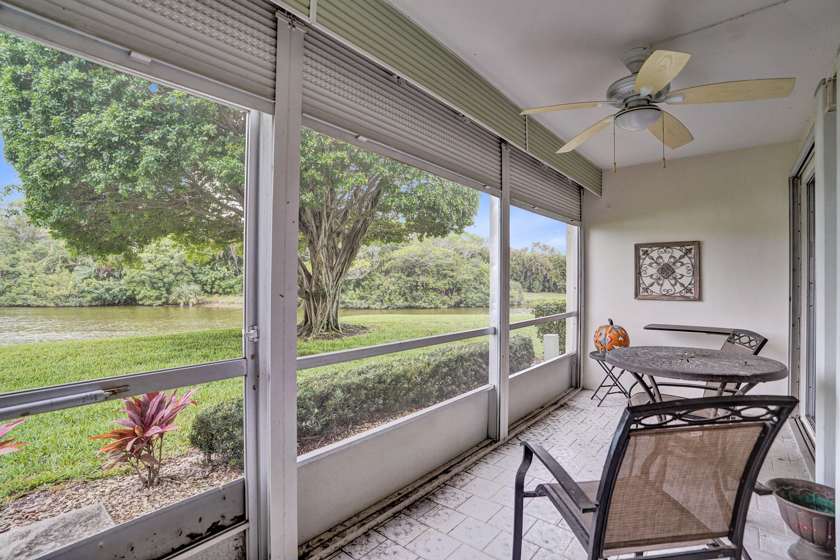 1033 Ainslie C Boca Raton, FL 33434 - Photo 38 of 42 a living room with a floor to ceiling window and a table