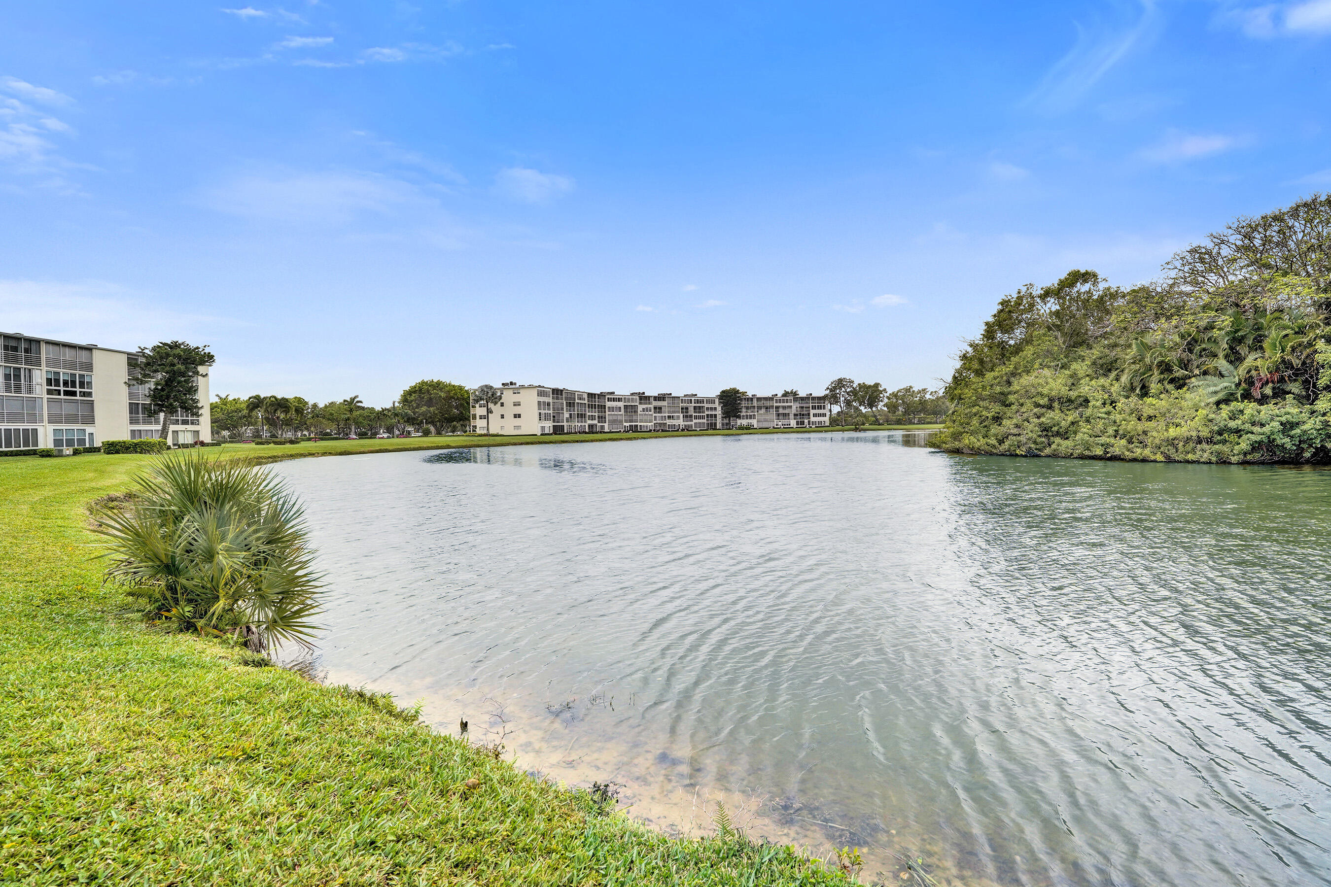 1033 Ainslie C Boca Raton, FL 33434 - Photo 41 of 42 a view of a lake with houses in the back