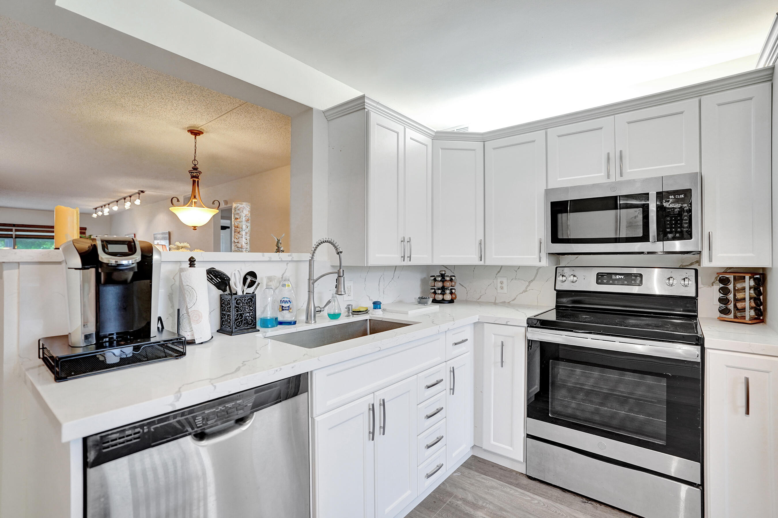 1033 Ainslie C Boca Raton, FL 33434 - Photo 9 of 42 a kitchen with a sink stove and microwave