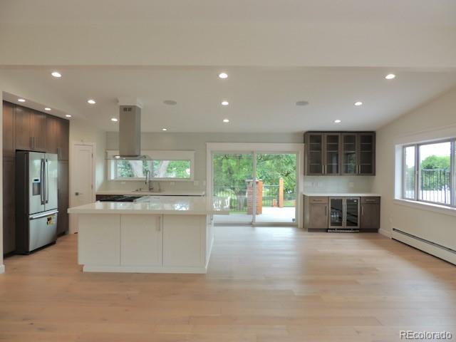 3255 Field Street Wheat Ridge, CO 80033 - Photo 13 of 35 a kitchen with stainless steel appliances granite countertop a stove top oven a sink dishwasher a refrigerator and a fireplace with wooden floor