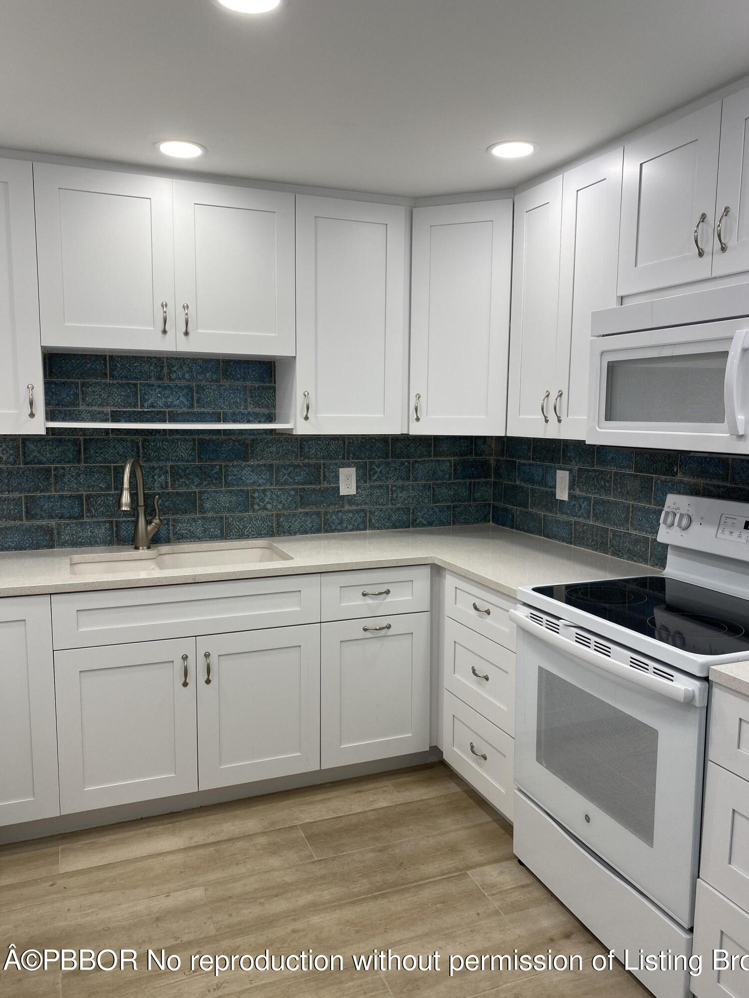 3800 Washington Road, Unit 610 West Palm Beach, FL 33405 - Photo 7 of 13 a kitchen with granite countertop white cabinets and white appliances