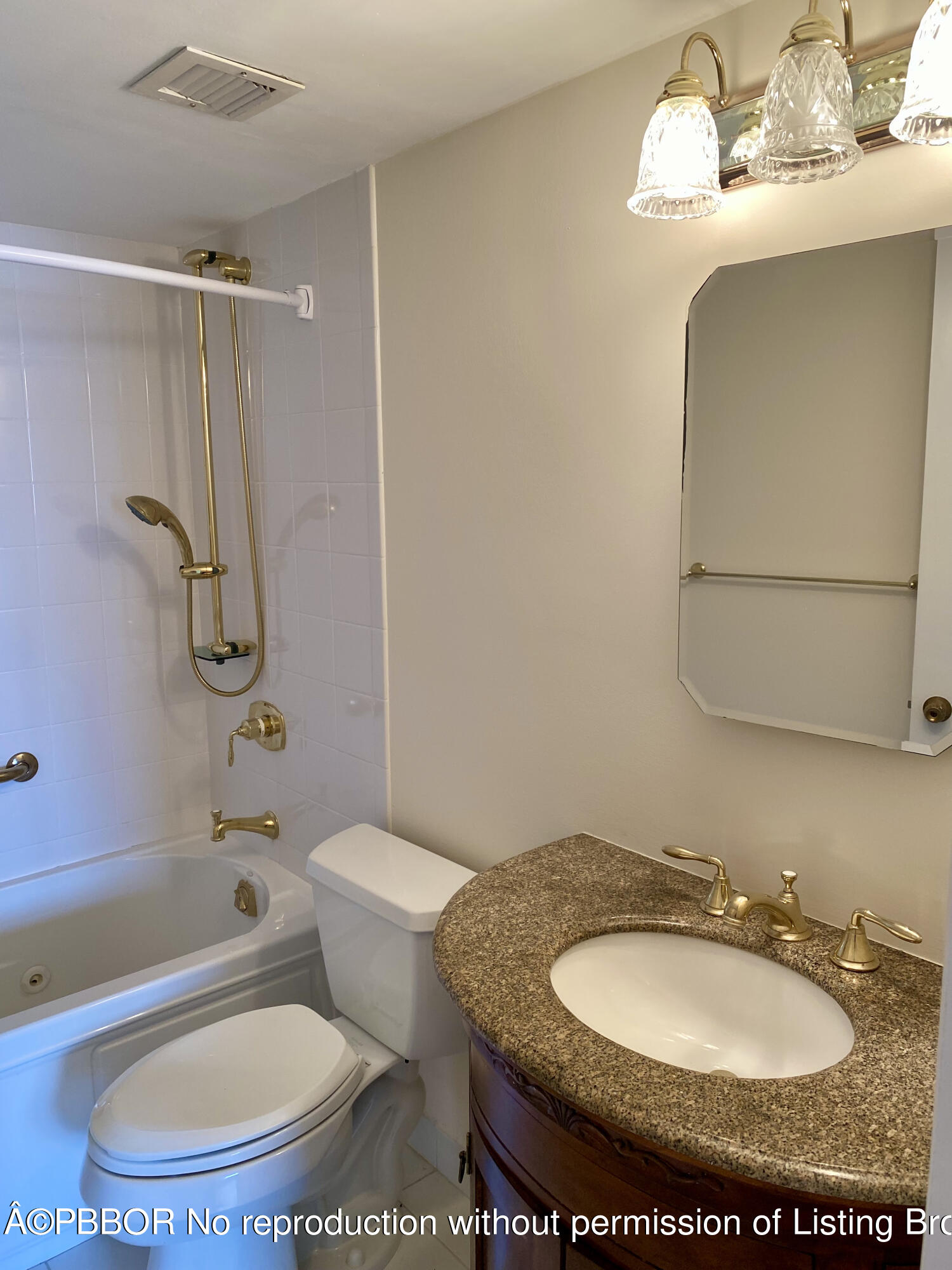 3800 Washington Road, Unit 610 West Palm Beach, FL 33405 - Photo 10 of 13 a bathroom with a granite countertop sink toilet a mirror and shower