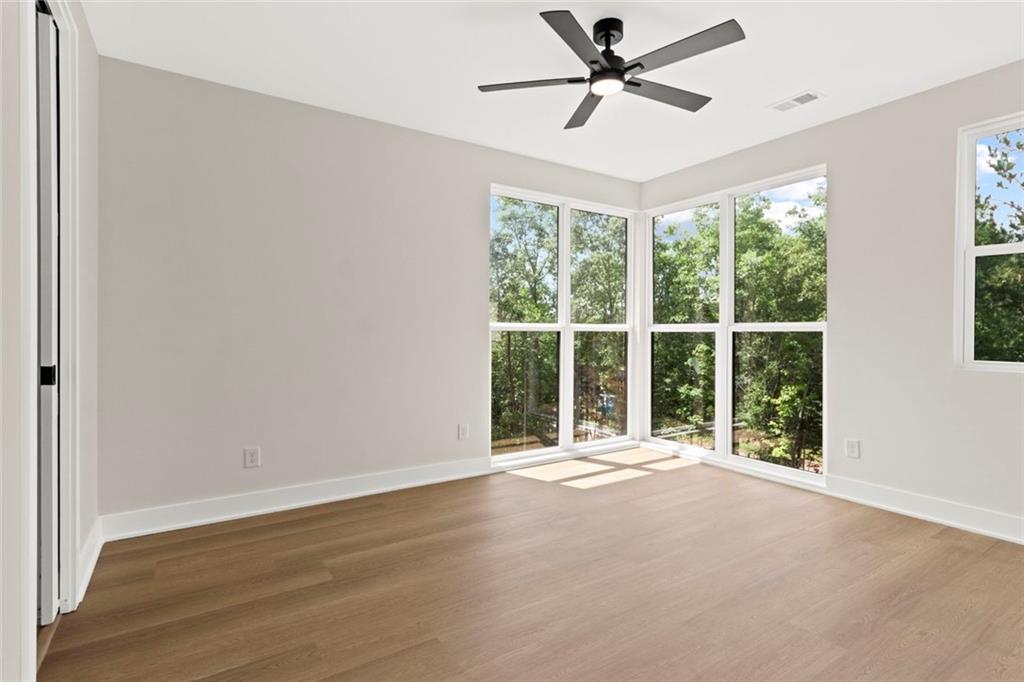 7066 Bells Way Fairburn, GA 30213 - Photo 42 of 64 a view of an empty room with a window and a ceiling fan