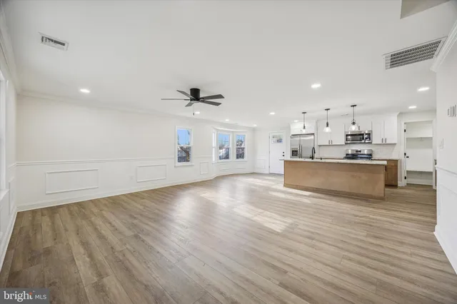 a view of a kitchen with a sink and wooden floor