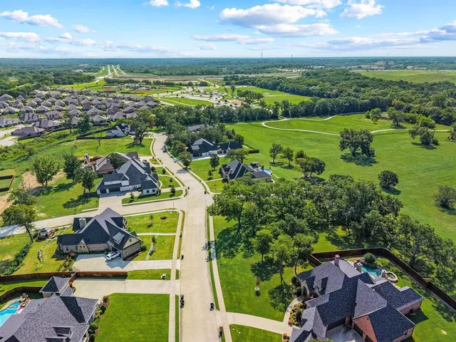 an aerial view of residential houses with outdoor space and ocean view