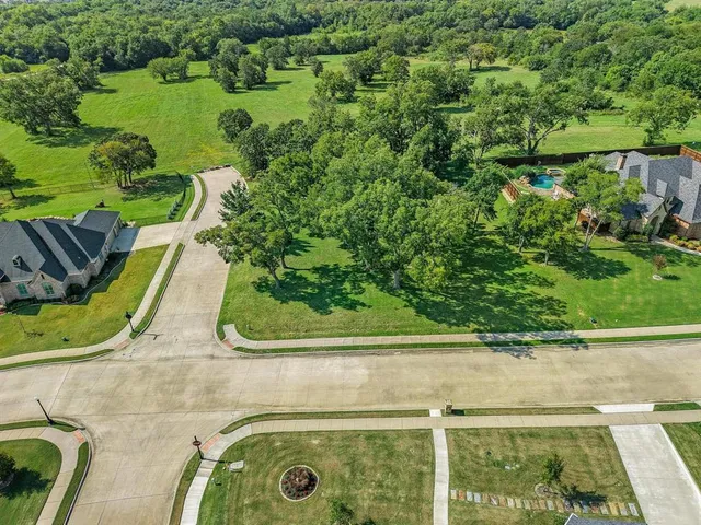 an aerial view of a residential houses with yard