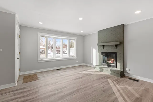a view of an empty room with a window and fire place