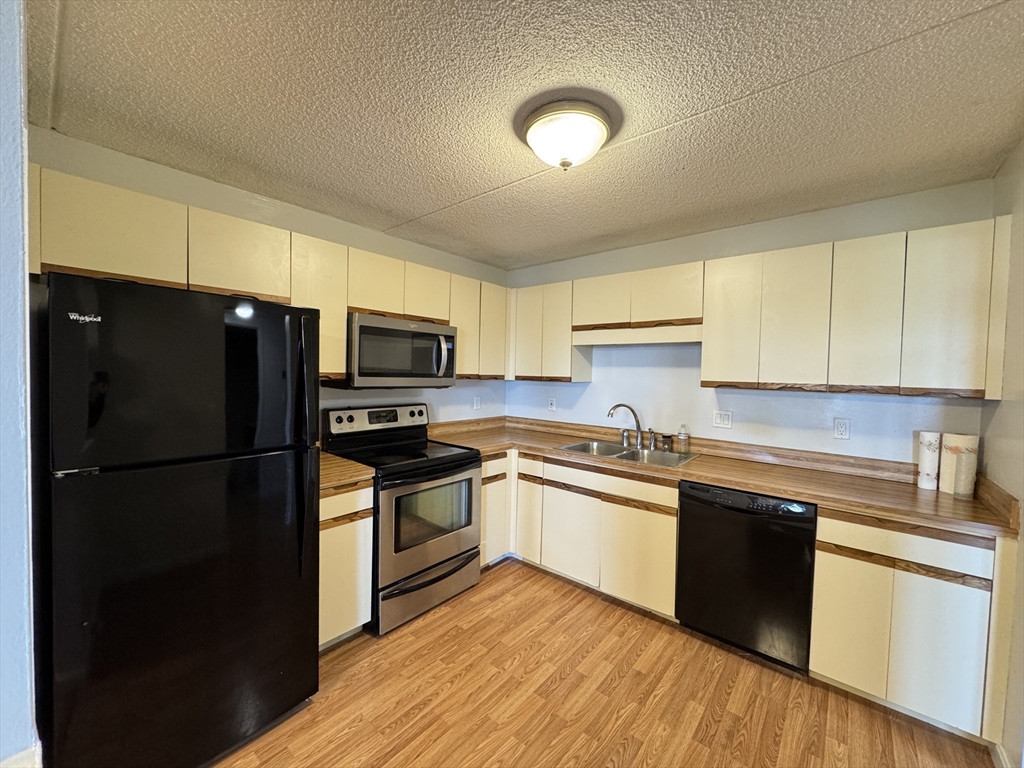 200 Cove Way, Unit 205 Quincy, MA 02169 - Photo 2 of 12 a kitchen with granite countertop a refrigerator stove top oven and sink
