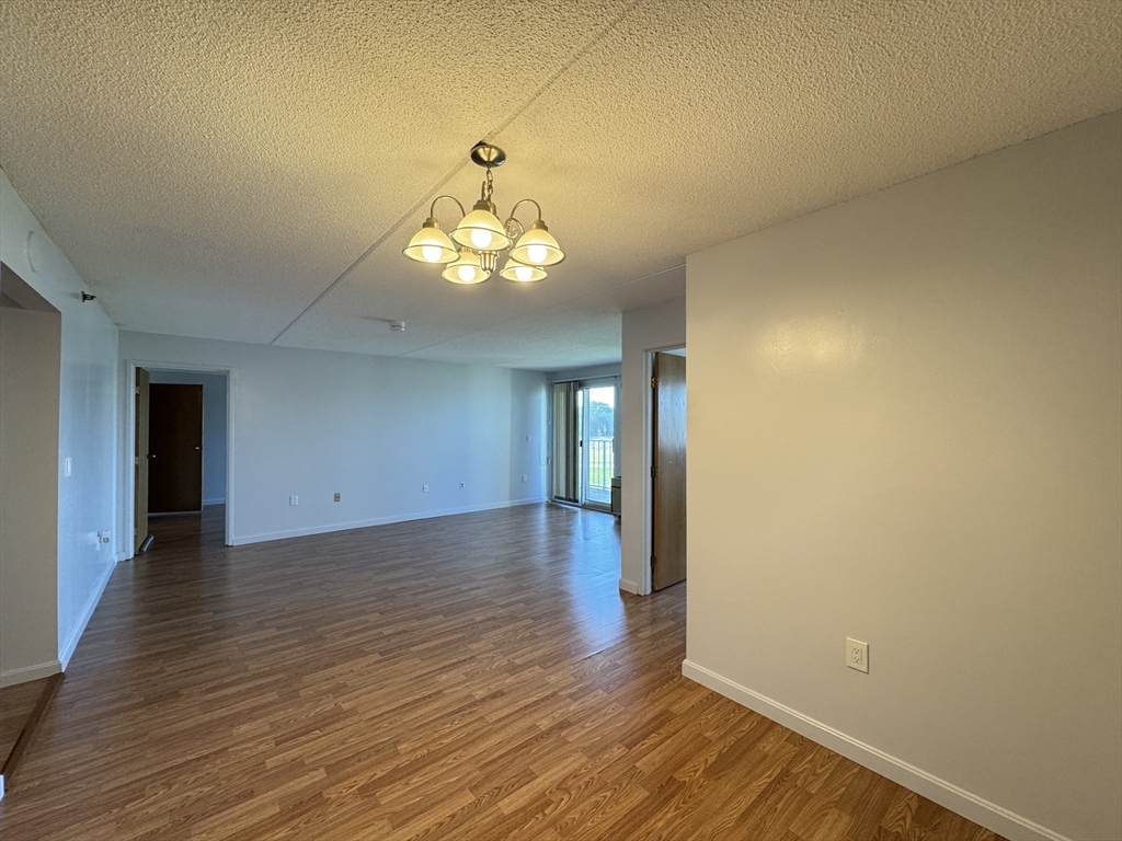 200 Cove Way, Unit 205 Quincy, MA 02169 - Photo 3 of 12 wooden floor in an empty room with a window