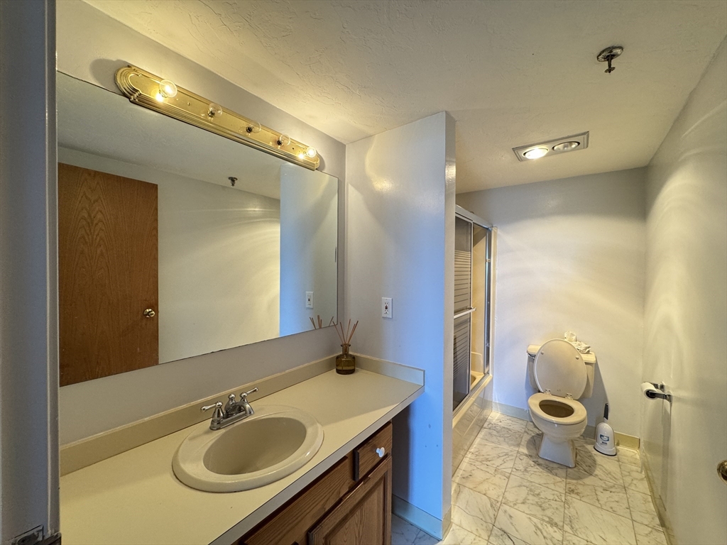 200 Cove Way, Unit 205 Quincy, MA 02169 - Photo 8 of 12 a bathroom with a sink double vanity and a mirror