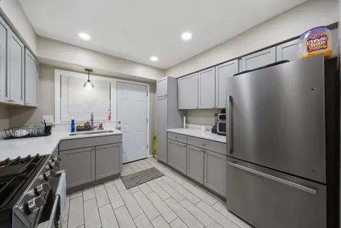 a kitchen with granite countertop a refrigerator stove and sink