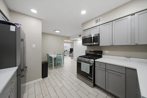 a kitchen with stainless steel appliances granite countertop a stove a sink and a refrigerator