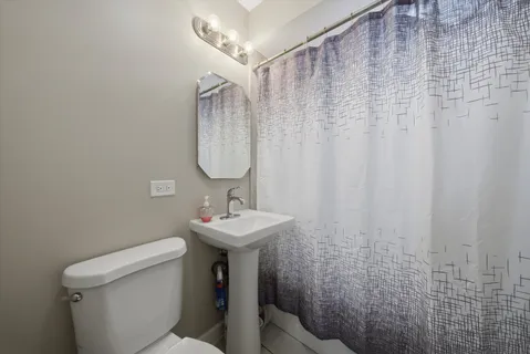 a bathroom with a sink a toilet and shower curtain