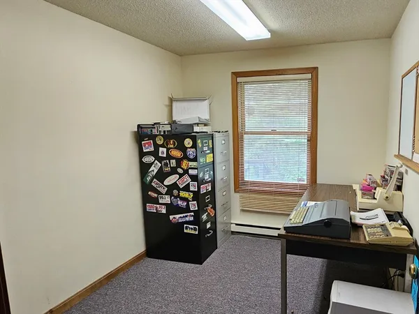 a view of a workspace with furniture and a window