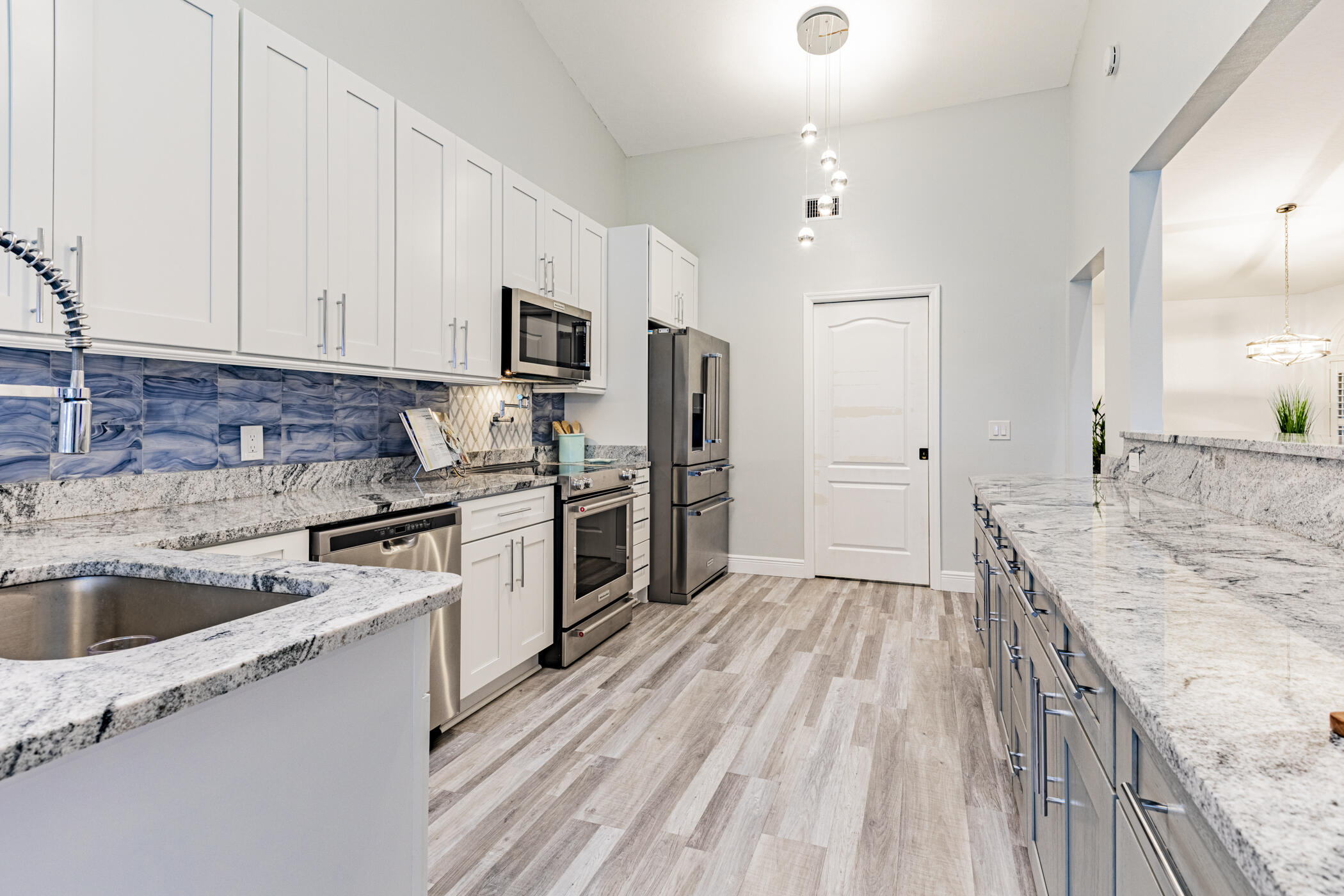 569 Dawson Drive Melbourne, FL 32940 - Photo 16 of 38 a kitchen with granite countertop a sink wooden floor and stainless steel appliances
