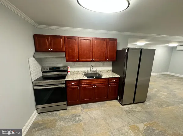 a kitchen with stainless steel appliances granite countertop a refrigerator a stove and a sink