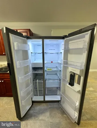 a kitchen with granite countertop a refrigerator and a stove top oven