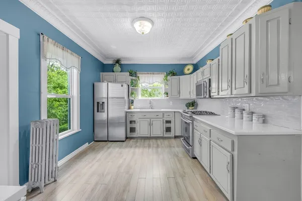 a kitchen with stainless steel appliances sink refrigerator and cabinets