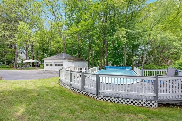 a view of a deck and backyard with large trees