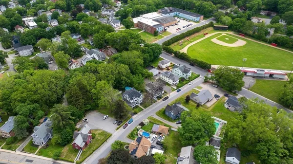 an aerial view of a residential houses with outdoor space and street view