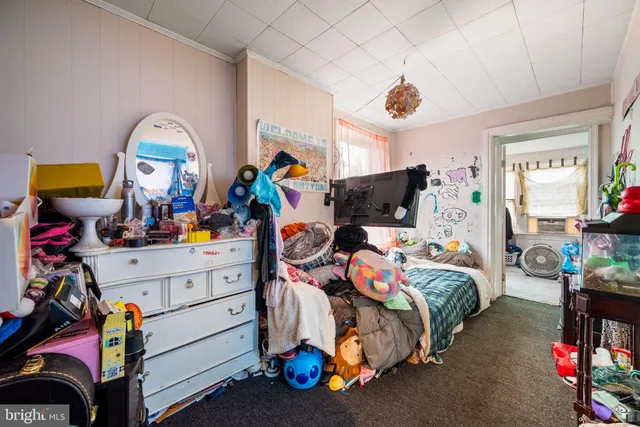 a bedroom with a bed a window and a flat screen tv