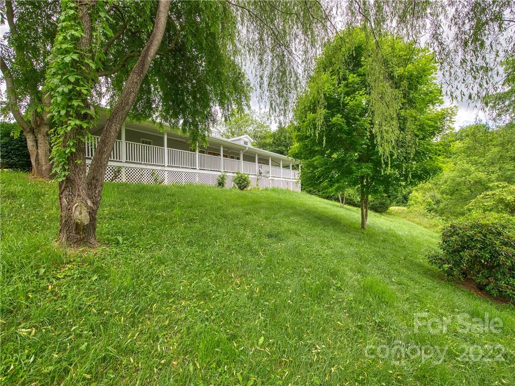 217 Durham Road Clyde, NC 28721 - Photo 1 of 24 a view of yard with green space and trees in the background