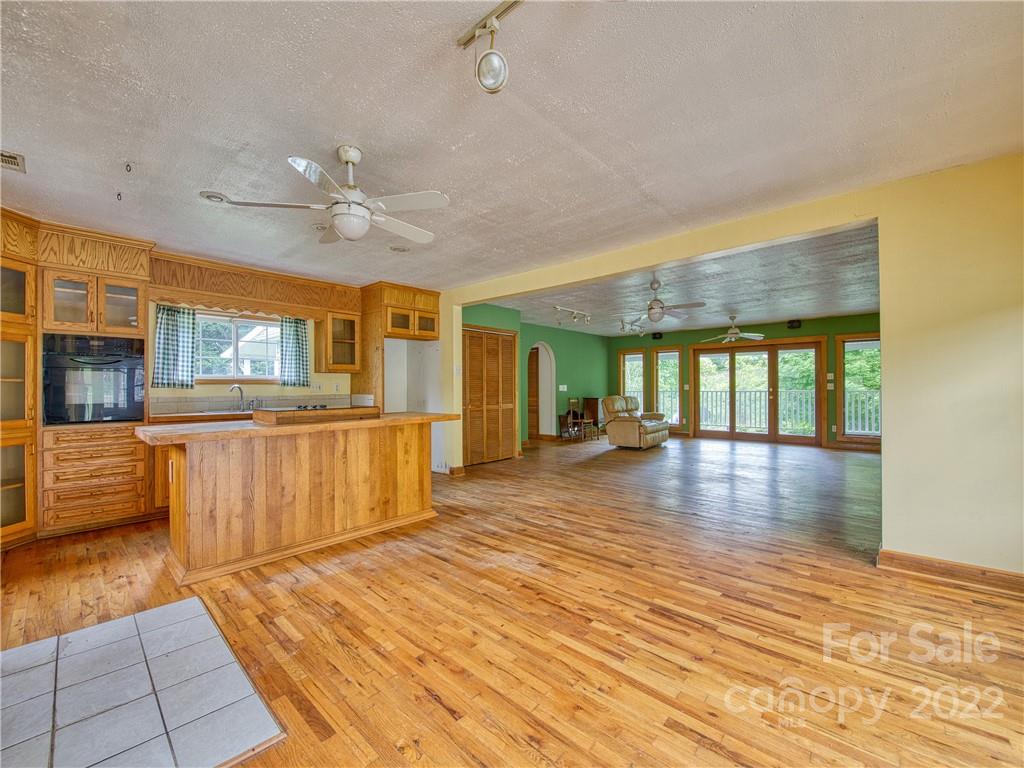 217 Durham Road Clyde, NC 28721 - Photo 14 of 24 a view of a kitchen with kitchen island a large counter space a sink appliances and cabinets
