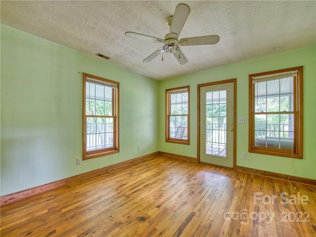 217 Durham Road Clyde, NC 28721 - Photo 17 of 24 a view of an empty room with a window and wooden floor