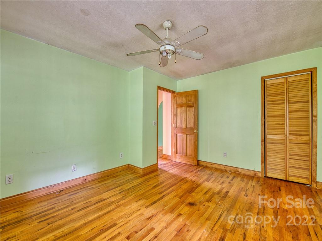 217 Durham Road Clyde, NC 28721 - Photo 18 of 24 a view of a room with a ceiling fan and hardwood floor