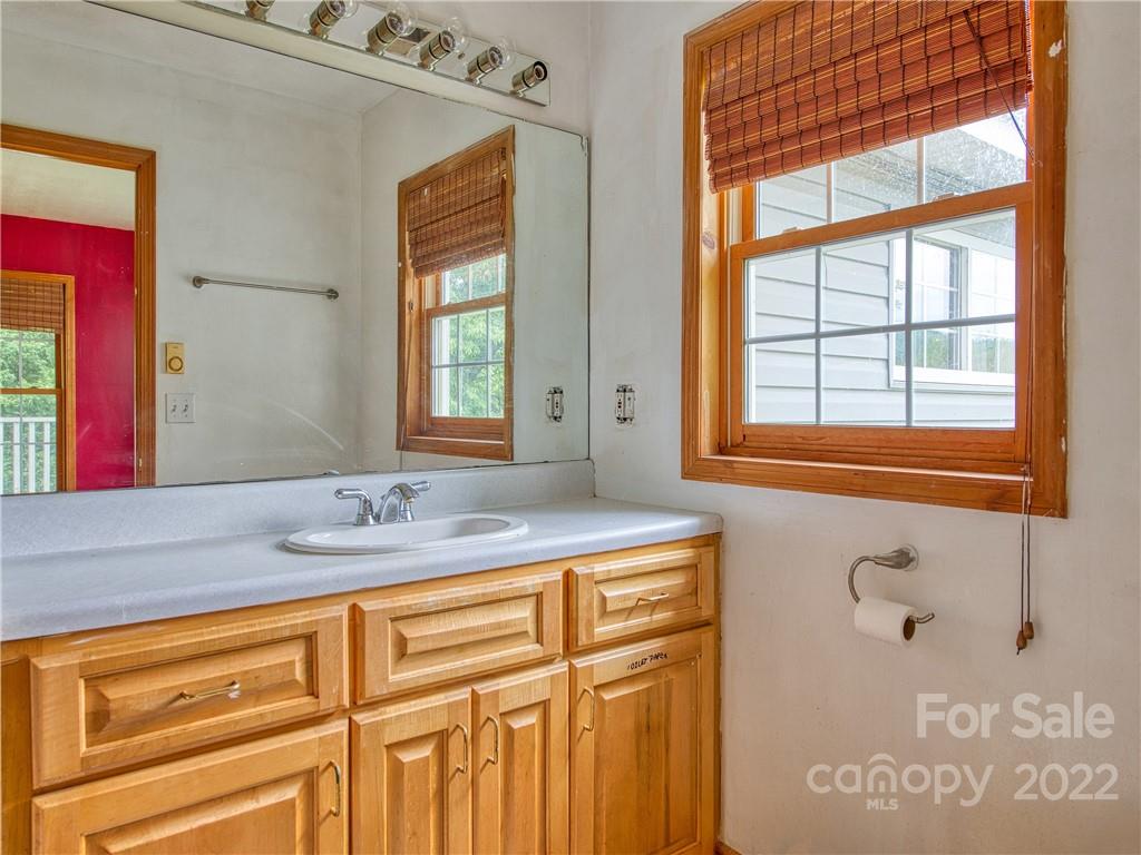 217 Durham Road Clyde, NC 28721 - Photo 24 of 24 a bathroom with a granite countertop sink and a mirror
