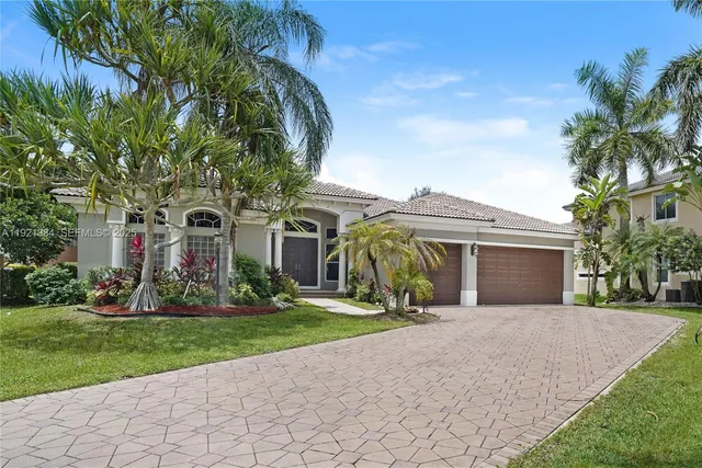 front view of house with a yard and potted plants