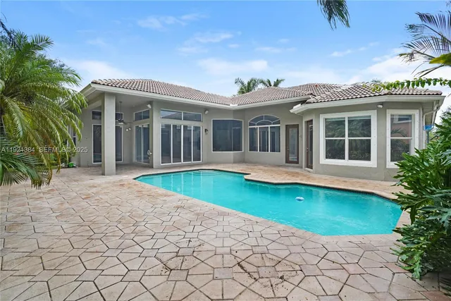a view of a house with a yard and potted plants