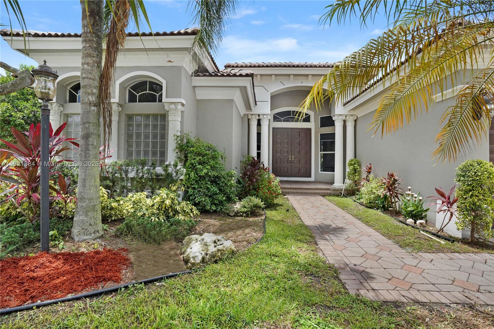 6713 Northwest 127th Terrace, Unit 1 Parkland, FL 33076 - Photo 2 of 15 a front view of a house with garden