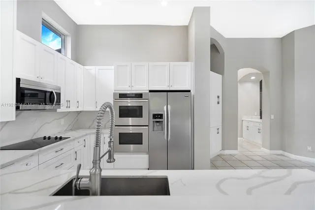 a kitchen with stainless steel appliances kitchen island granite countertop a refrigerator and a stove top oven