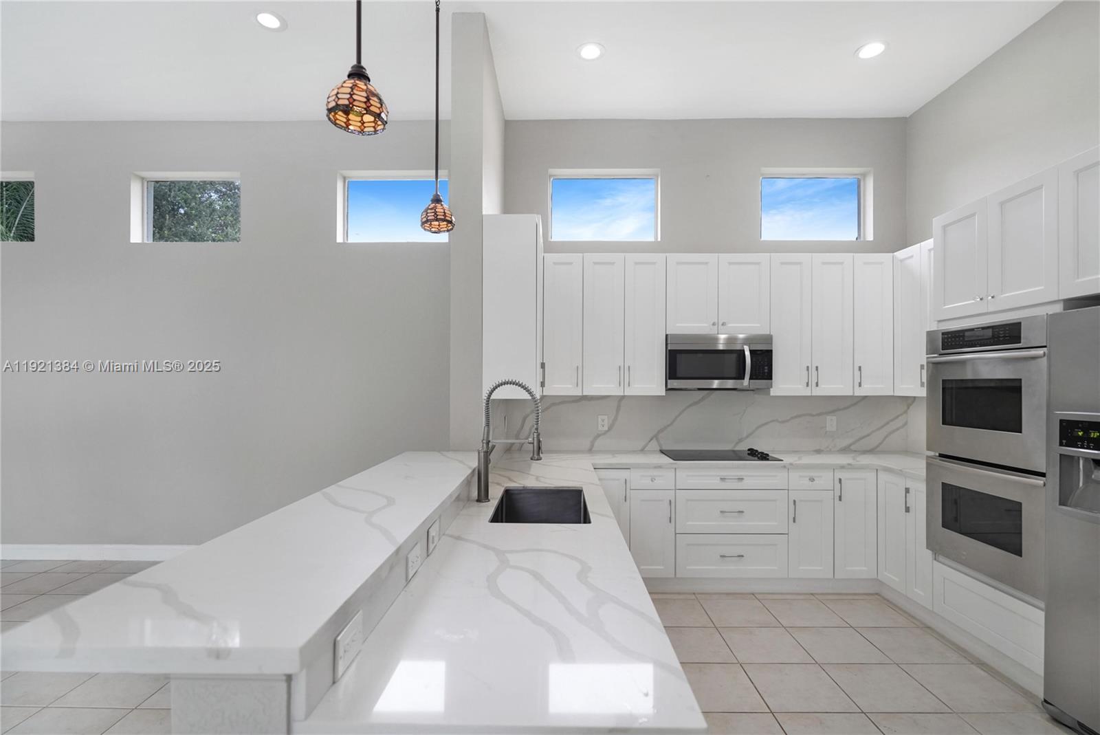 6713 Northwest 127th Terrace, Unit 1 Parkland, FL 33076 - Photo 7 of 15 a kitchen with stainless steel appliances a stove a sink and a refrigerator