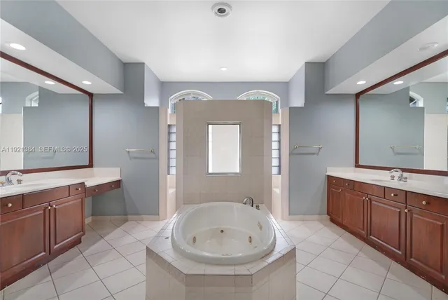 a spacious bathroom with a double vanity sink mirror and bathtub
